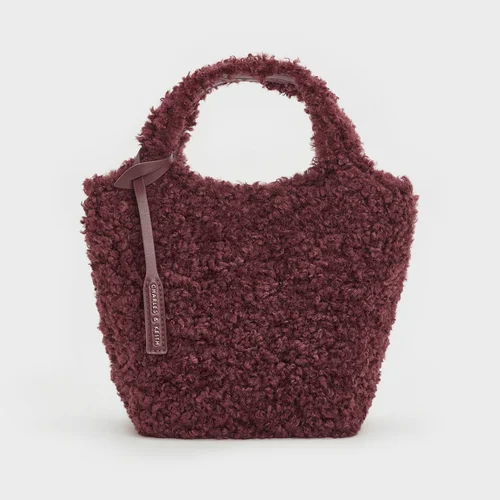 Burgundy fluffy bag on a plain grey background. Autumn High Street Finds