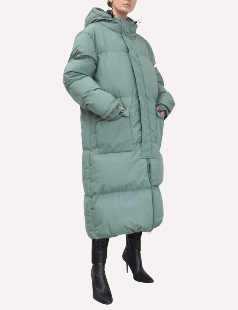 Model poses wearing moss green long puffer coat