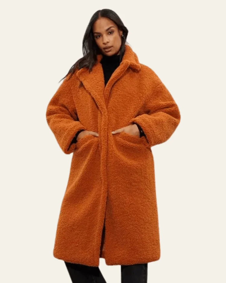 Model wears rust orange teddy coat