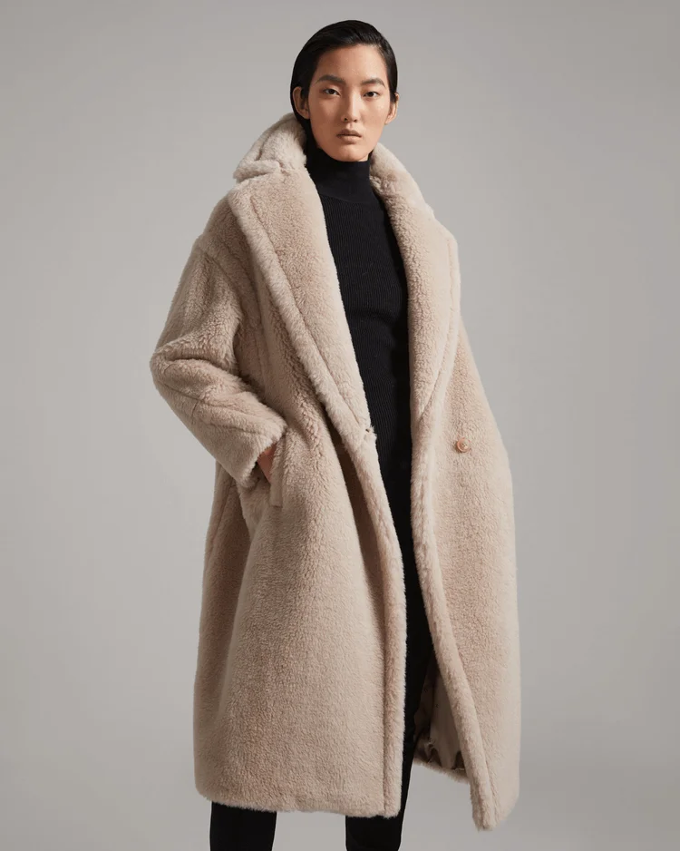 Model woman wears a beige teddy bear coat