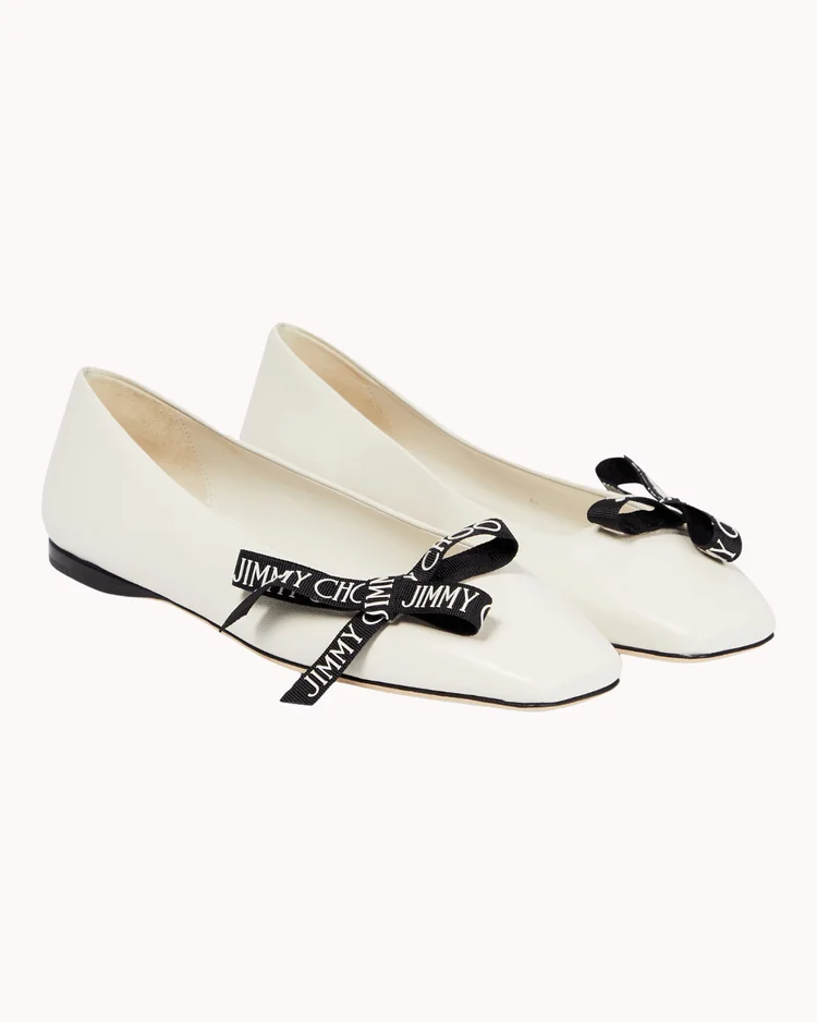 White ballet flat shoes with black bows