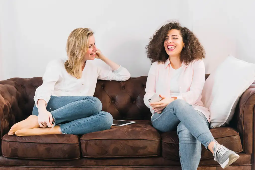 two female friends talking on a sofa