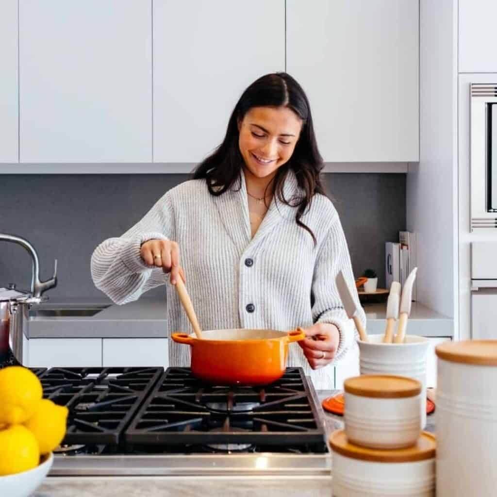 happy woman cooking a meal at home