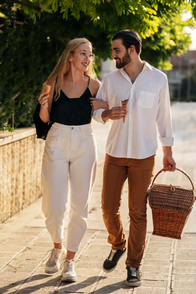 a young couple walking with a picnic basket