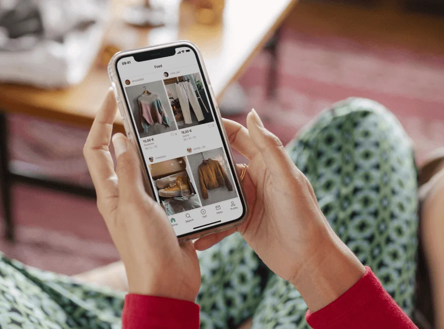 women browsing clothes on vinted using on mobile phone. 