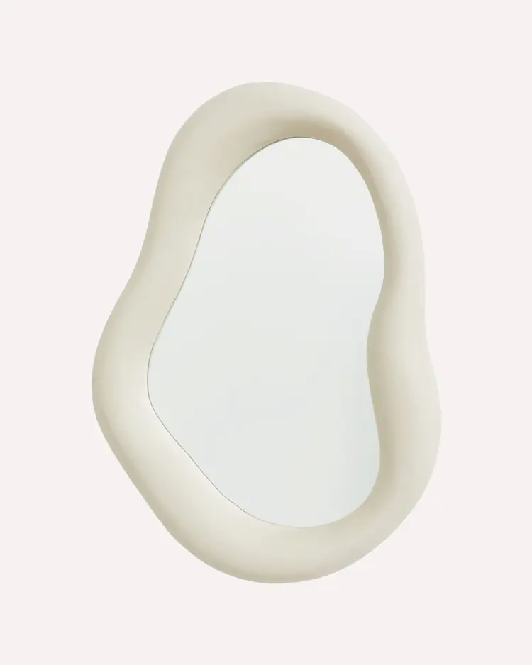 Light beige asymmetric mirror on a plain light grey background