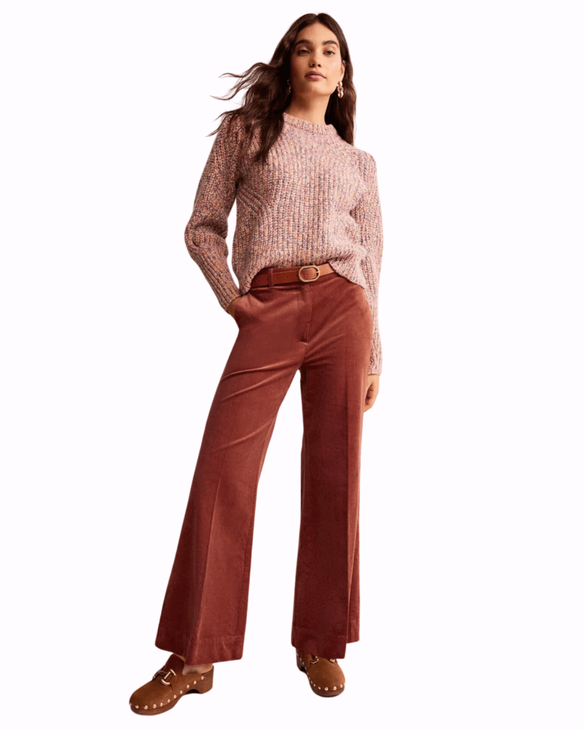 Model poses wearing red corduroy trousers