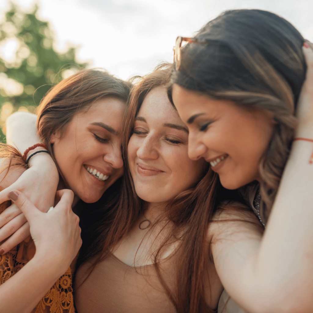 Three female friends hugging