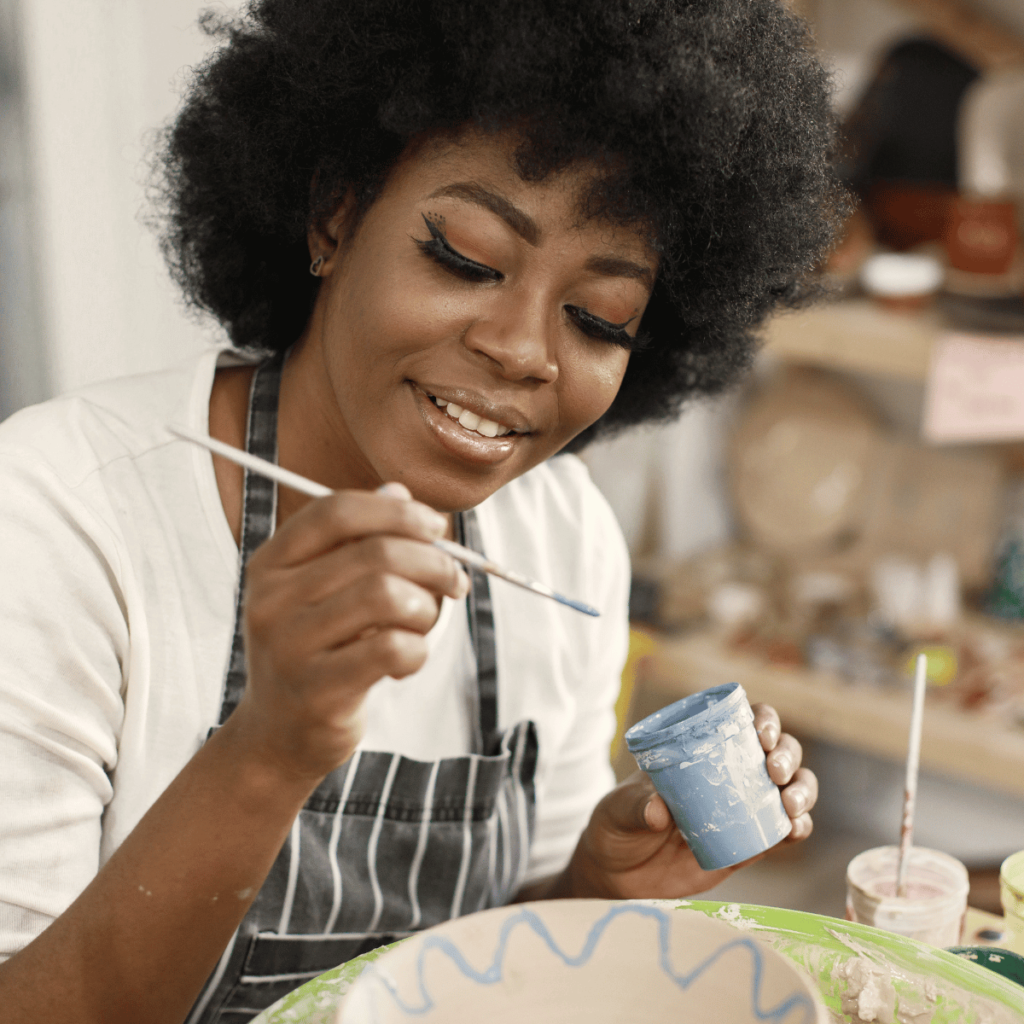 Woman smiles as she paints