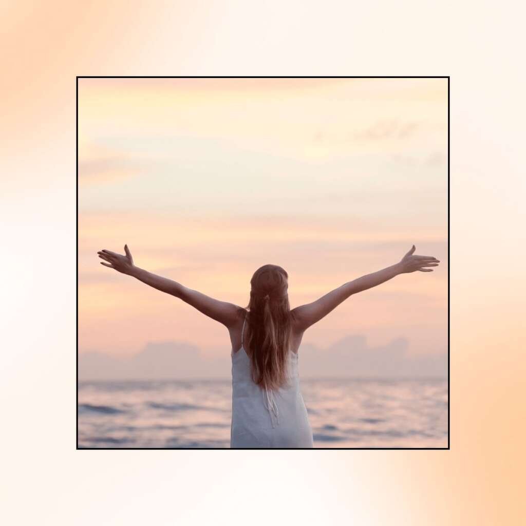 Rear View of Woman With Arms Raised at Beach during Sunset