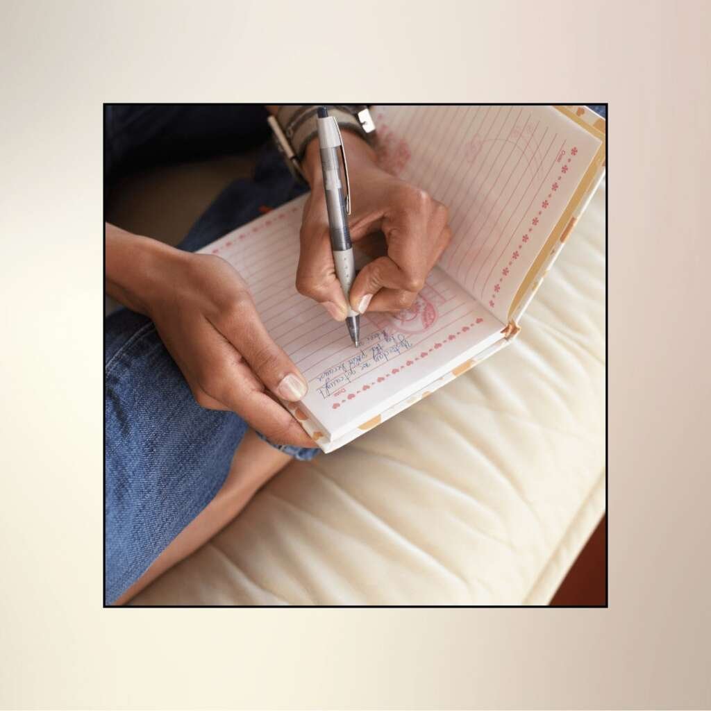 Woman's hands writing in journal