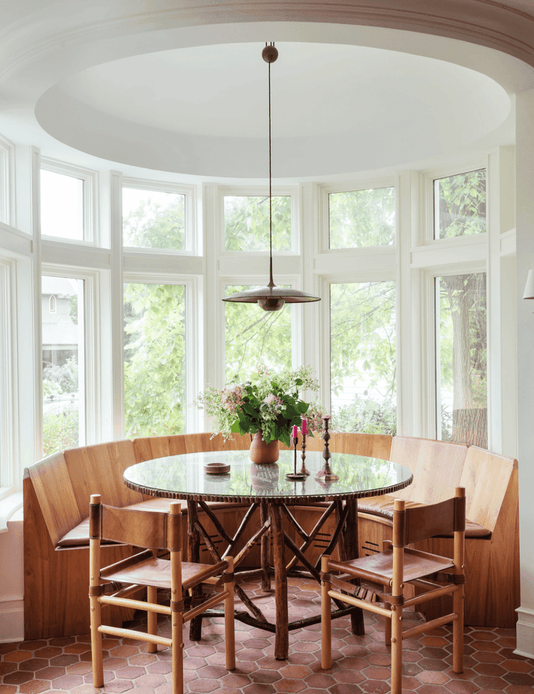 breakfast nook in a bowed window space with a high ceiling