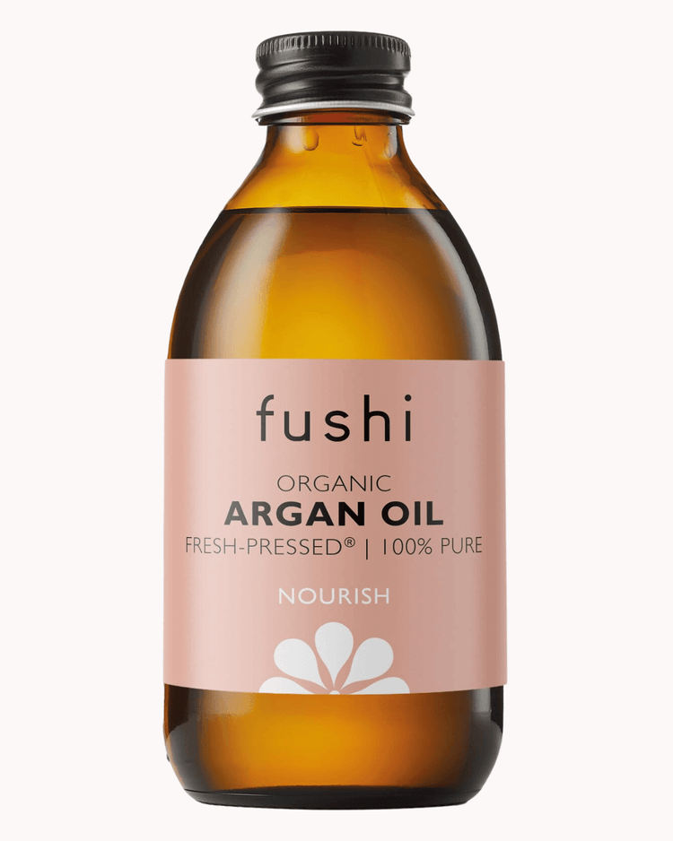 Argan oil bottle on a plain pastel pink background