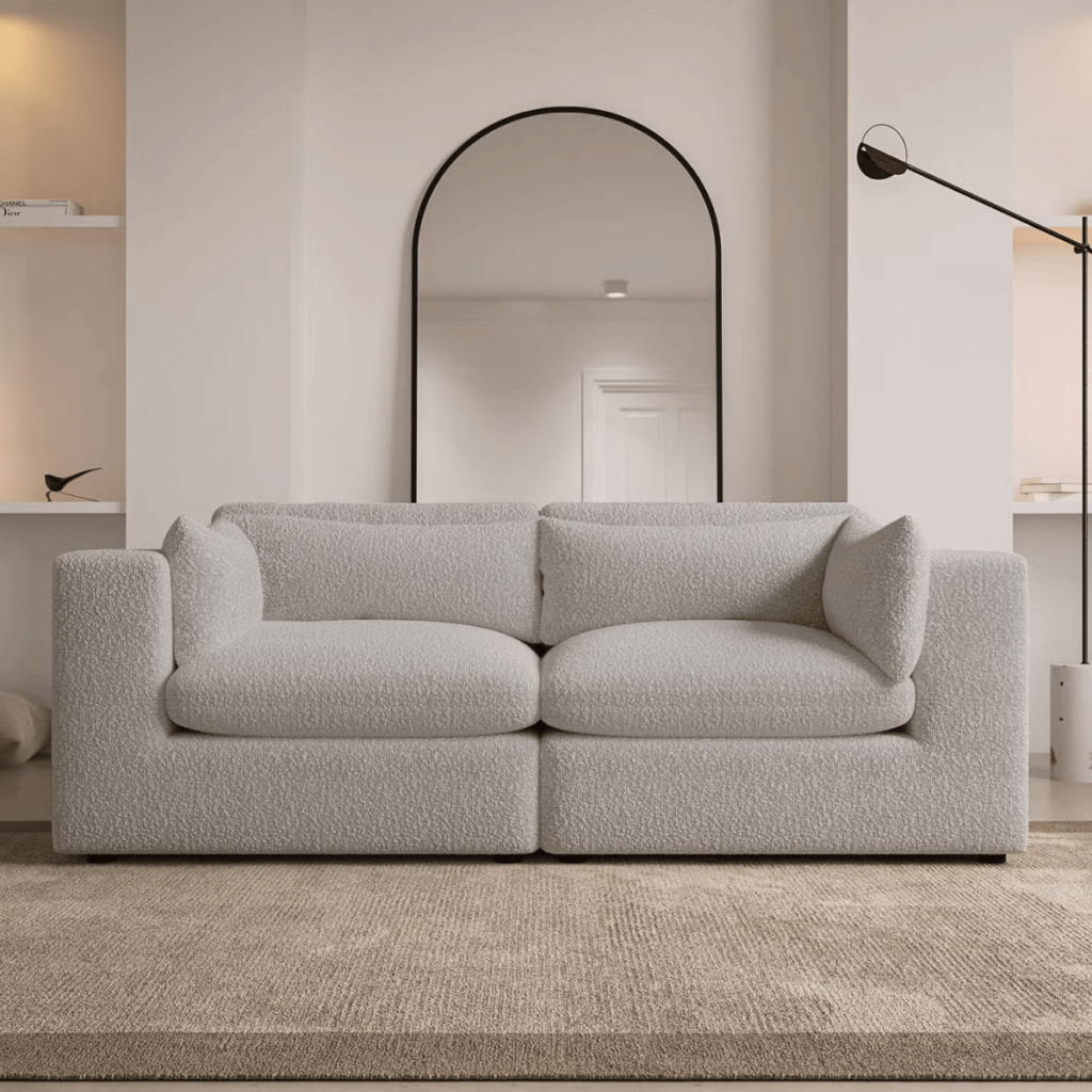 Beige Boucle 3 Seater Sofa in a light neutral living room with a black framed mirror and black floor lamp. 