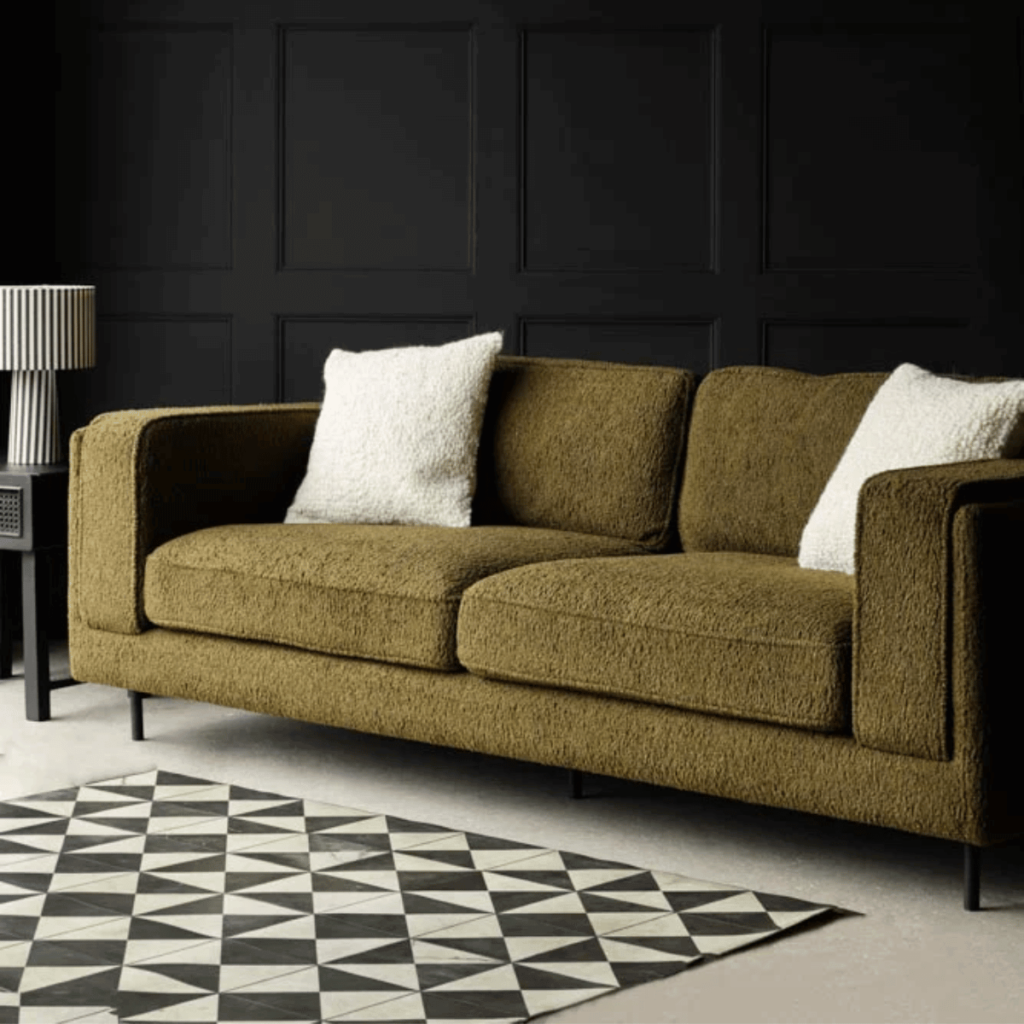 Olive Chunky Boucle Sofa in a dark living with black panelled walls. BEST BOUCLE SOFAS