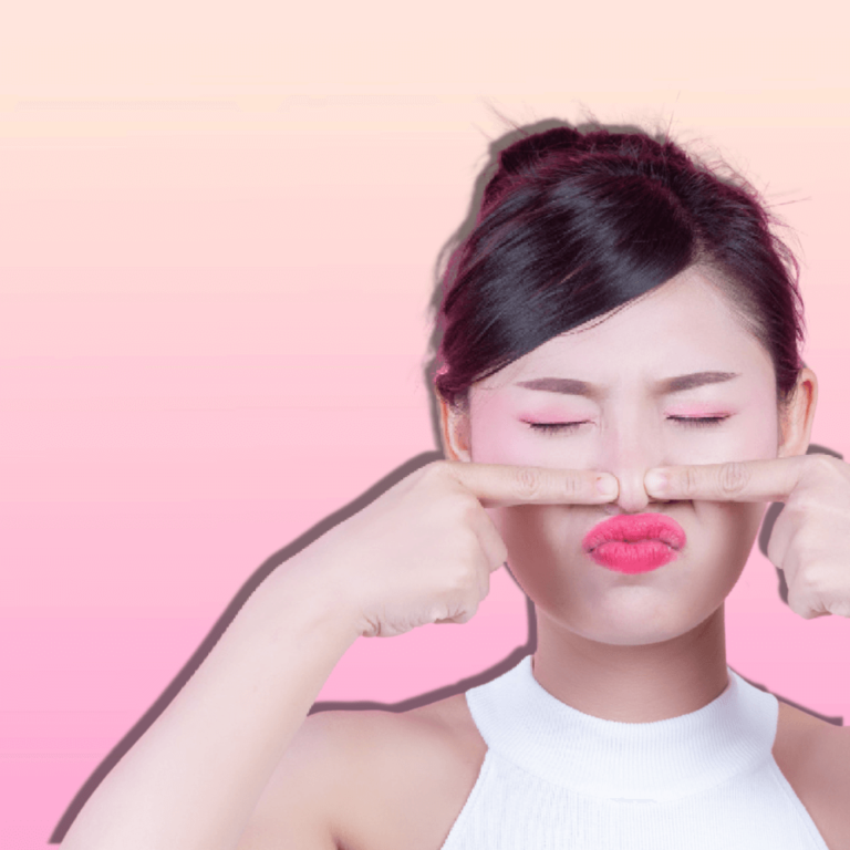 Young Asian squeezing her nose against a plain pink background. Blackhead treatment concept