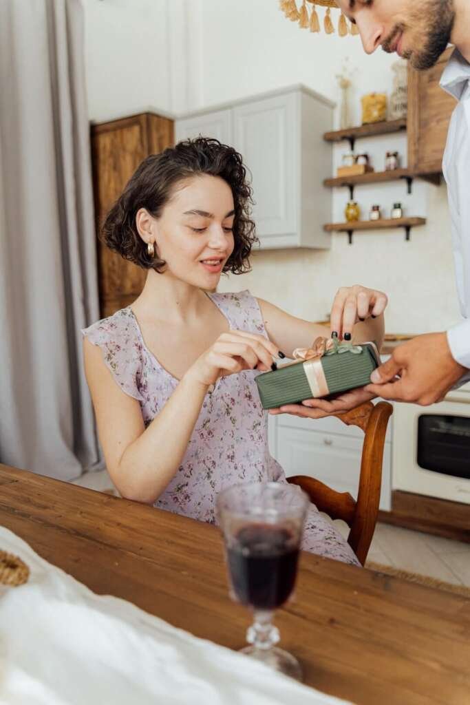 Man handing a present to a woman. What is love bombing