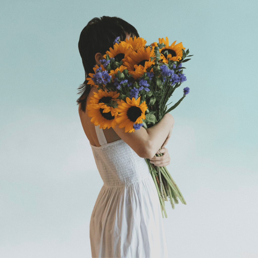 Woman holding a bouquet of sunflowers. 