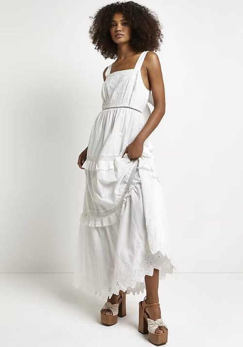 Model with curly hair wearing a White Broderie Smock Maxi Dress