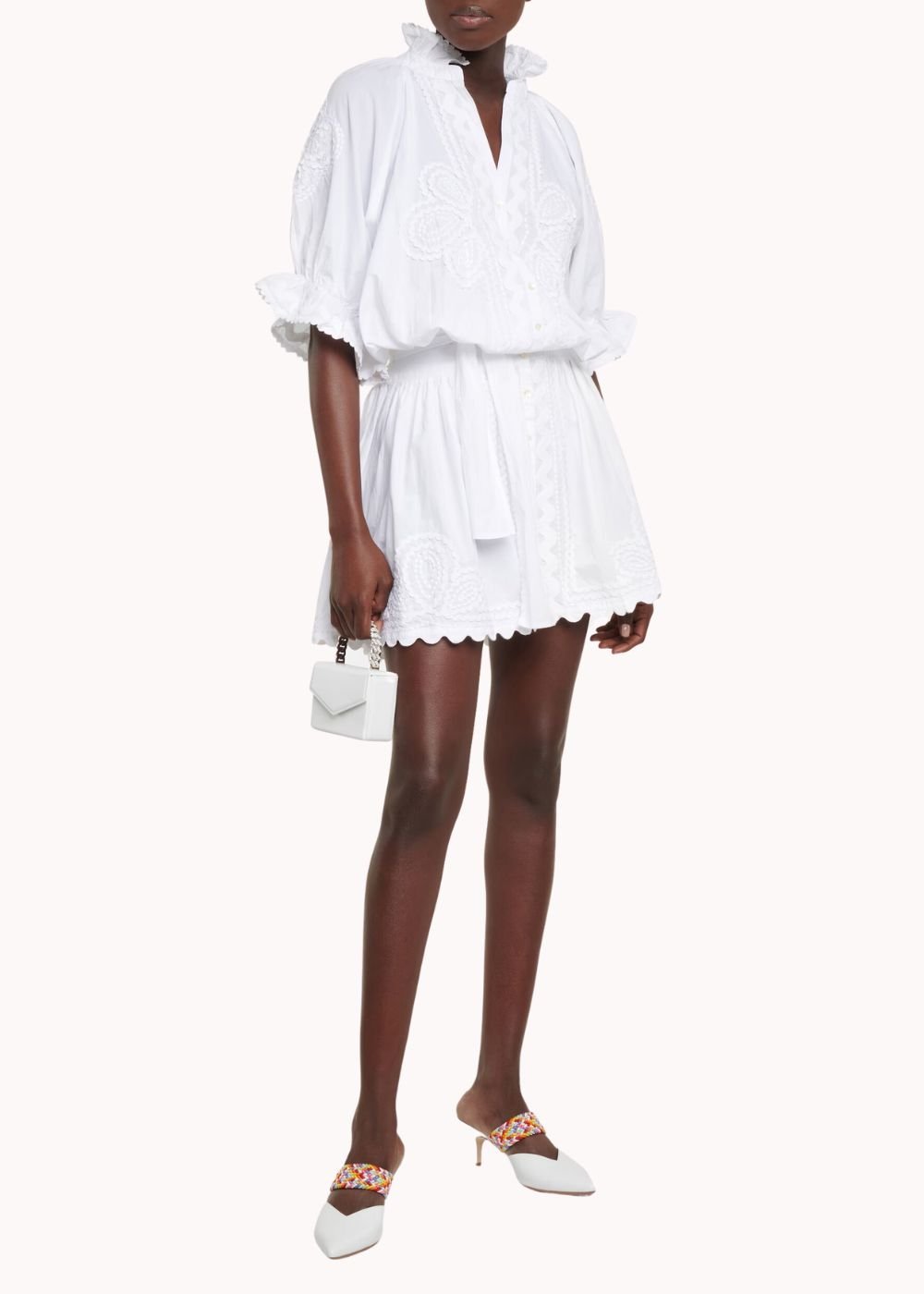 Model wearing a white embroidered cotton minidress