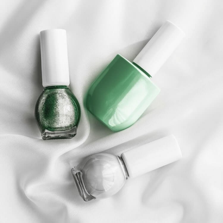 Nail polish bottles on silk background, french manicure products