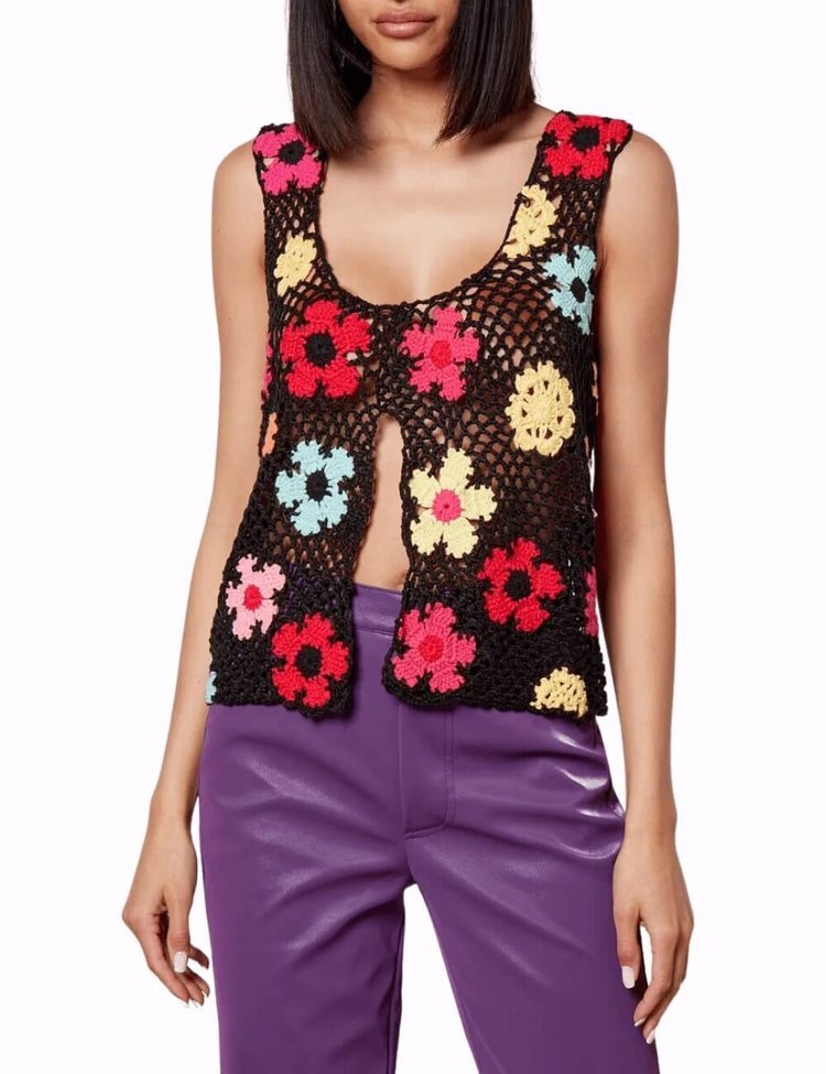 Model wearing a black crochet top with multicolour flowers.