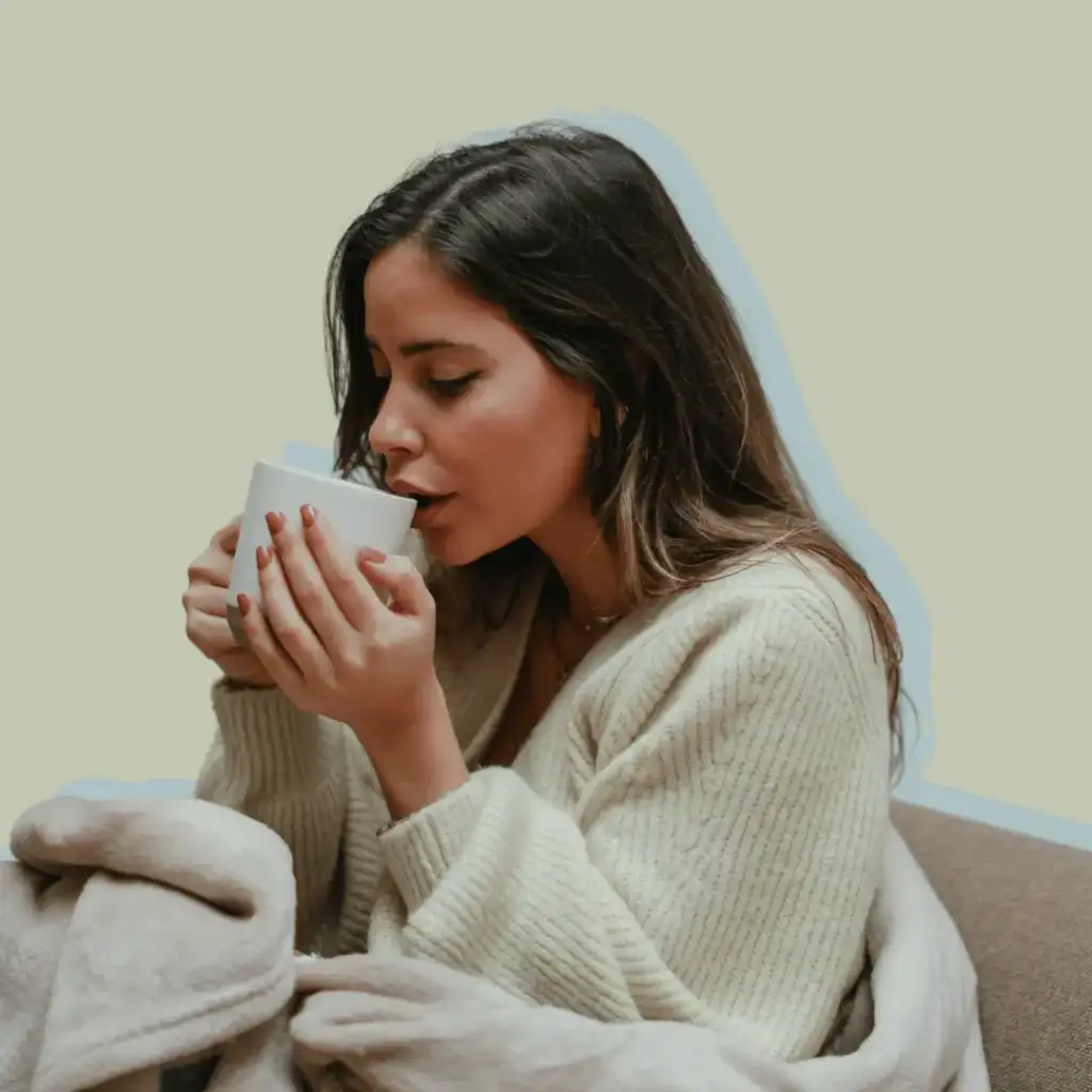 Self-Care Morning Rituals. Woman in a cosy cardigan drinking from a cup