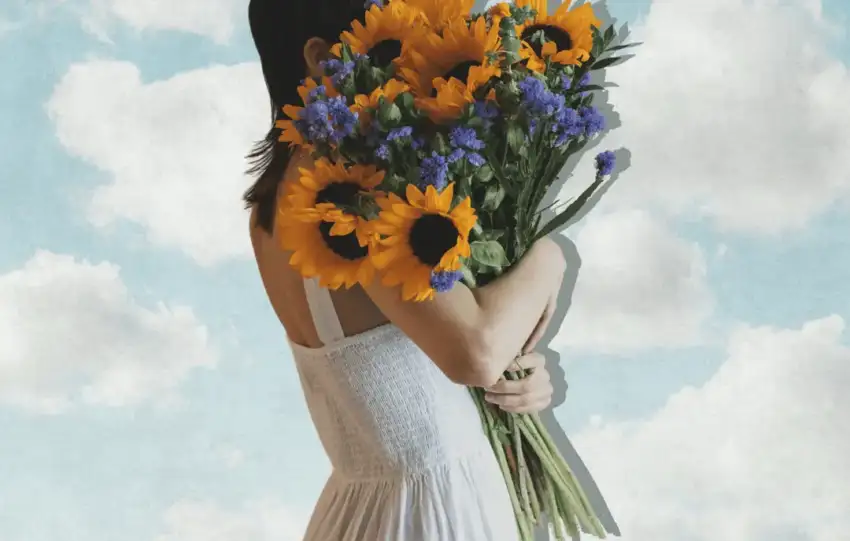 Woman in a white dress holding sunflowers