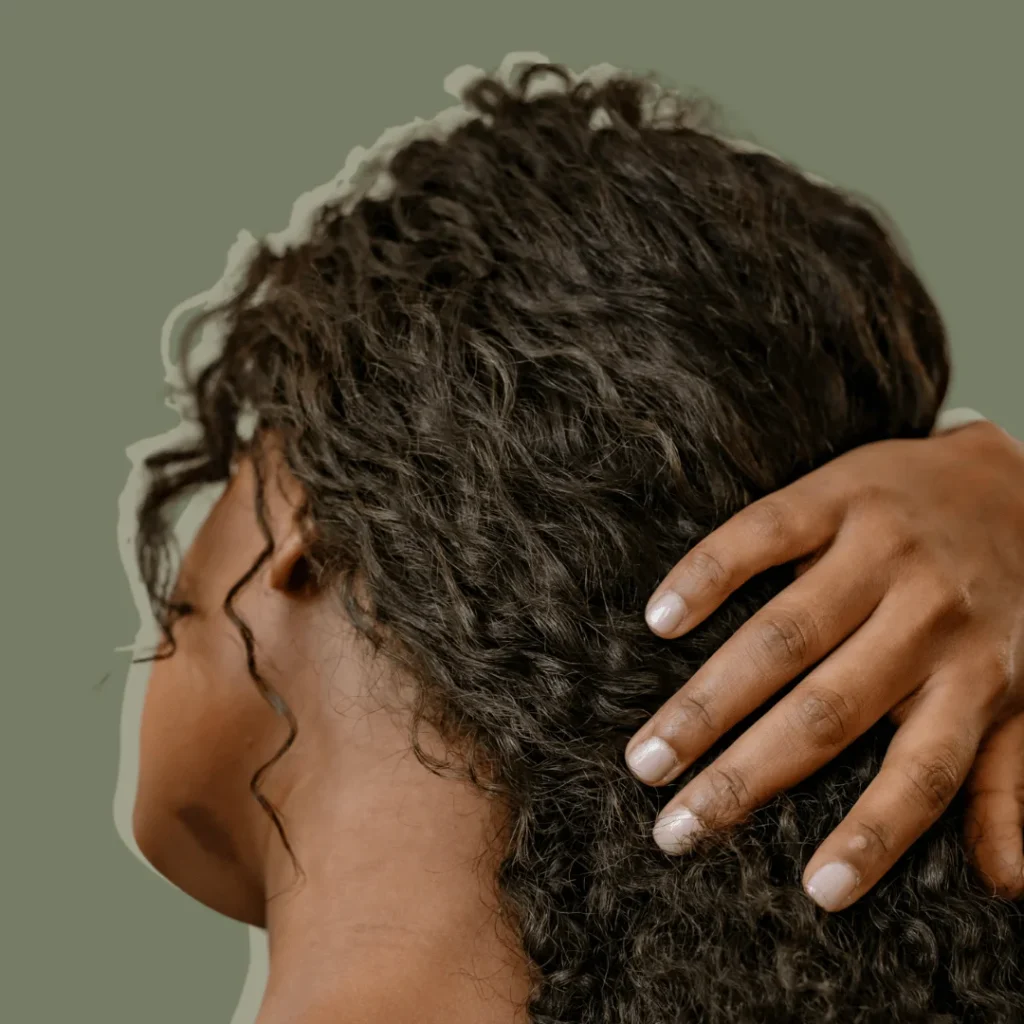 back view of woman touching her curly hair