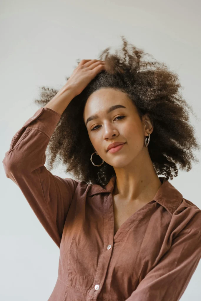 Woman with afro hair wearing a brown blouse