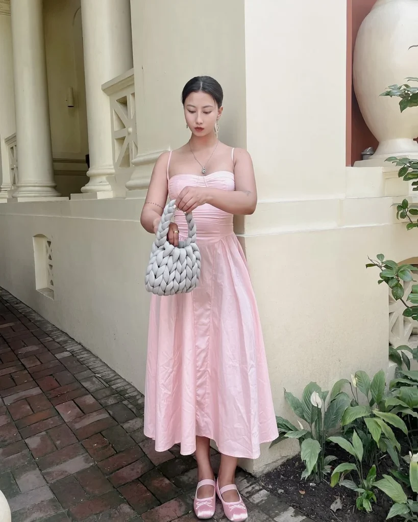 woman wearing a long pink dress with ballet shoes