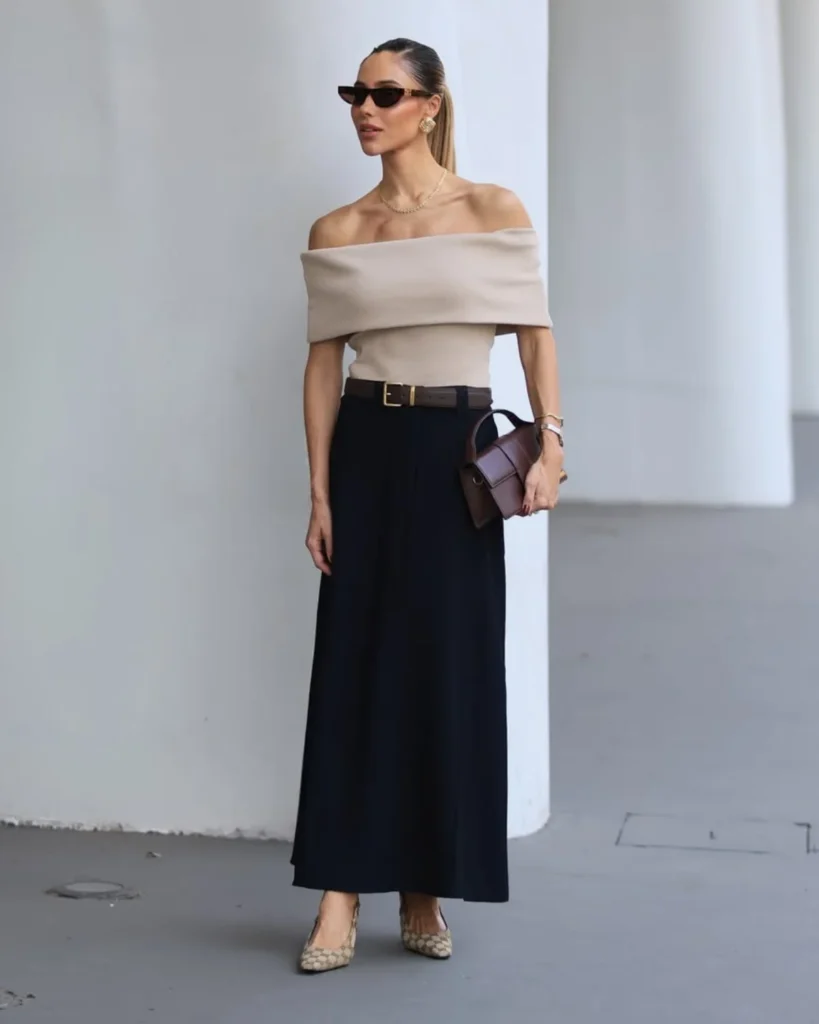 White woman wearing an off the shoulder knitted top with maxi a-line black skirt